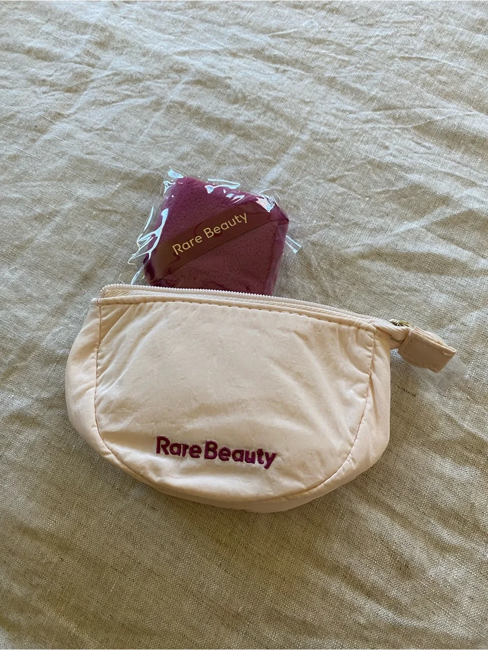 Rare Beauty pressed powder compacts in warm beige and tan tones